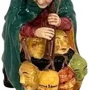Royal Doulton porcelain figurine "The Mask Seller" HN 2103, depicting a man in a green cloak and black hat holding a collection...
