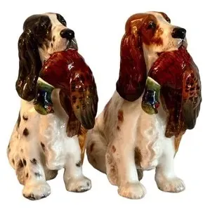 Pair of vintage Royal Doulton HN138 porcelain spaniel figurines, each depicting a hunting dog holding a pheasant in its mouth, with...