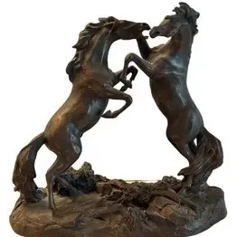 Bronze sculpture depicting two rearing horses in a dynamic pose, mounted on a textured naturalistic base.