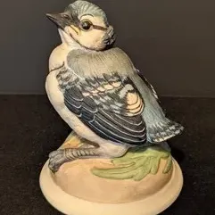 Vintage Goebel porcelain blue jay figurine, featuring detailed hand-painted feathers in shades of blue, grey, and white, perched on a...