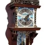 Vintage Dutch Zaandam wall clock featuring a wooden case, brass weights, and ornate metalwork detailing.