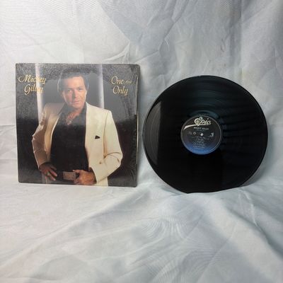 Sale Photo Thumbnail #37: Mickey Gilley "One And Only" vinyl record album, released on Epic Records. Includes the original album jacket, which remains partially in its original shrink wrap. The vinyl disc is visually in good condition with minor surface wear consistent with age an