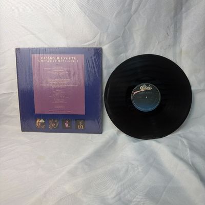 Sale Photo Thumbnail #34: Tammy Wynette - Greatest Hits Vol. 4 vinyl record album. Released on Epic Records. Includes the original album jacket, which remains partially in its original shrink wrap. The vinyl disc is visually in good condition with some light surface dust. Perfect 