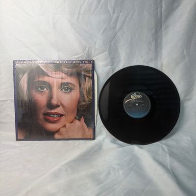 Sale Photo Thumbnail #33: Tammy Wynette - Greatest Hits Vol. 4 vinyl record album. Released on Epic Records. Includes the original album jacket, which remains partially in its original shrink wrap. The vinyl disc is visually in good condition with some light surface dust. Perfect 