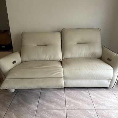 Beige Vegan Leather Recliber Couch with one seat partially reclined.