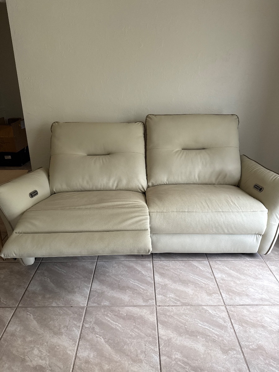 Beige Vegan Leather Recliber Couch with one seat partially reclined.