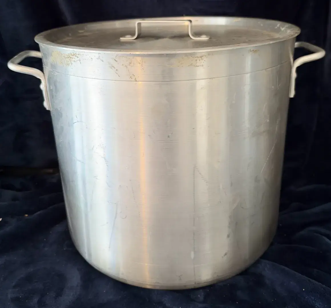 Heavy-duty commercial aluminum stock pot with a matching lid.