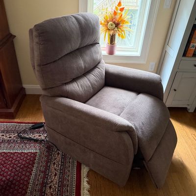Modern power lift recliner chair upholstered in a textured taupe fabric, featuring a tiered backrest and wired remote control.