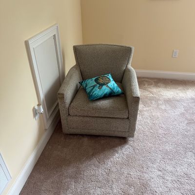 Contemporary upholstered armchair in a neutral textured fabric, styled with a blue sea turtle accent pillow.