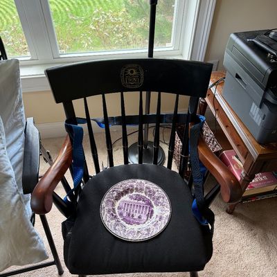 Amherst College captain's chair in black and cherry finish, featuring the college seal on the backrest, paired with a purple...