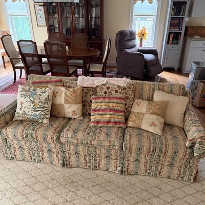 Traditional three-cushion sofa with a striped floral tapestry upholstery, styled with various decorative throw pillows, shown in a living...