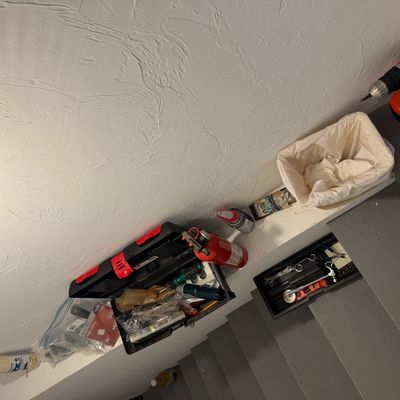 Assorted household tools and supplies, including a Black & Decker cordless drill, a plastic toolbox with contents, a small fire...