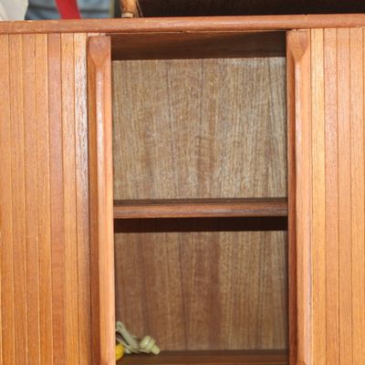 Mid-century Danish modern style teak cabinet featuring sliding tambour doors and interior shelving.