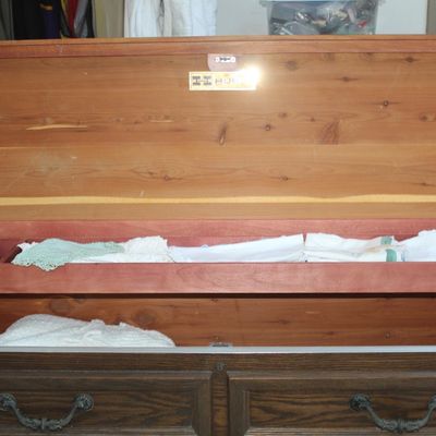 Open Lane cedar chest featuring an interior sliding tray, brass hardware, and storage compartment filled with linens.