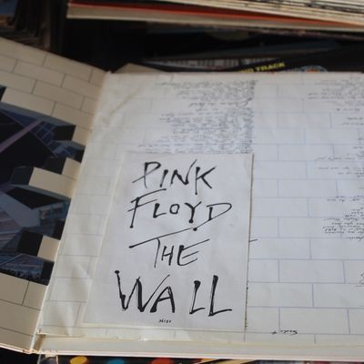 Open gatefold vinyl album of Pink Floyd's "The Wall" featuring interior artwork and lyric insert.