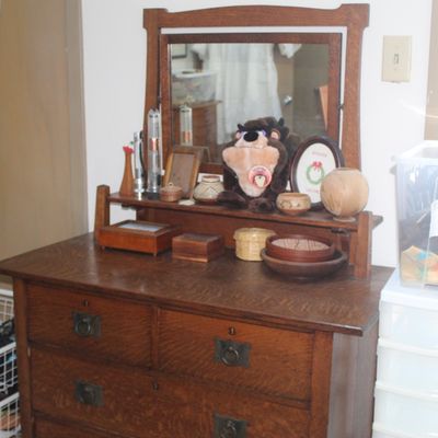Antique Arts and Crafts style quarter-sawn oak dresser with attached swivel mirror and dark metal ring pulls.