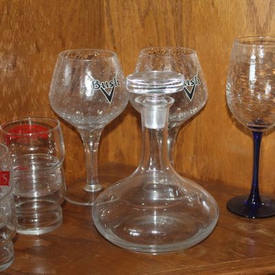 Collection of barware including a clear glass wine decanter with stopper, branded Bush and Merry's Irish Cream glasses, and a wine...