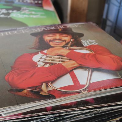 Chuck Mangione "Feels So Good" vinyl LP album, released in 1977, resting atop a stack of vintage records.