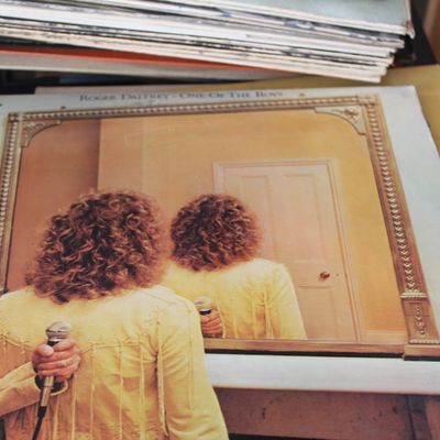 Vinyl LP album cover for Roger Daltrey's "One of the Boys," released in 1977, resting atop a stack of records.