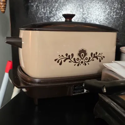 Vintage West Bend electric multi-purpose cooker in a beige and brown color scheme, featuring a retro floral decal on the front.