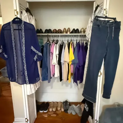 Assorted women's clothing, including a sheer blue kimono, denim jeans, t-shirts, and various shoes displayed in a closet.