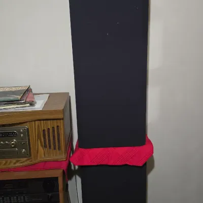 Sony floor-standing tower speaker with black fabric grille, shown alongside vintage audio equipment.