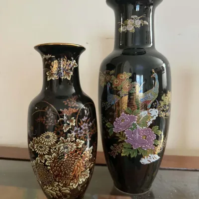 Pair of vintage Japanese black porcelain Chokin-style vases, featuring detailed floral and peacock motifs with gold accents.