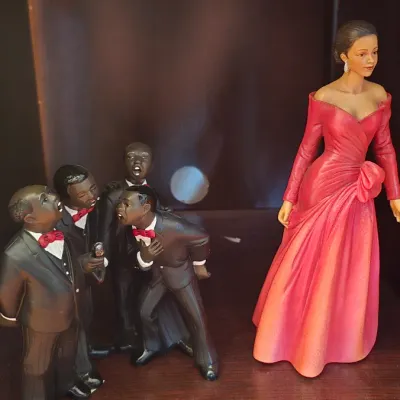 African American musical figurines, featuring a four-man doo-wop group in black tuxedos and a female vocalist in an elegant red gown.