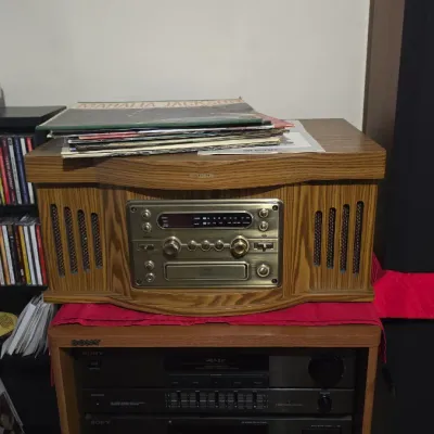 Crosley retro-style wooden turntable and radio console, sitting atop a vintage Sony stereo system stack with cassette deck and receiver.