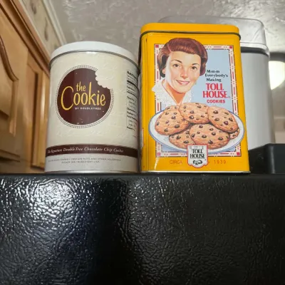 Vintage-style cookie tins, including a round DoubleTree chocolate chip cookie tin and a rectangular yellow Toll House cookie tin...