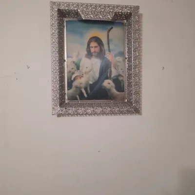 Vintage framed print of Jesus as the Good Shepherd, housed in an ornate, silver-toned filigree metal frame.
