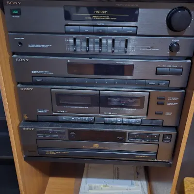 Vintage Sony stereo system stack including an HST-231 receiver, dual cassette deck, and 5-disc CD changer, housed in a wood grain media...