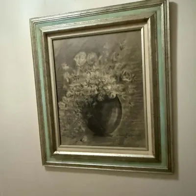Vintage still life painting of flowers in a vase, rendered in muted tones and housed in an ornate silver-gilt and mint green wooden frame.