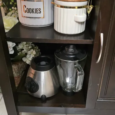 Farberware stainless steel blender and a pair of white ceramic canisters with wooden lids, displayed on a dark wood rolling kitchen cart.