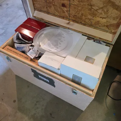 Sale Photo Thumbnail #76: Large wooden storage crate filled with boxed glassware and collectibles, including Avon Hummingbird Collection items.