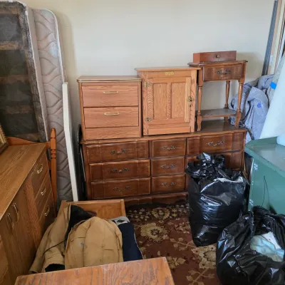 Sale Photo Thumbnail #4: Assorted vintage wooden furniture, including a large nine-drawer dresser, a small two-drawer nightstand, a wooden cabinet, and a small side table, circa late 20th century.