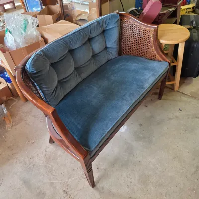 Sale Photo Thumbnail #71: Vintage mid-century modern style settee featuring a wooden frame with caned sides and blue velvet tufted cushions.