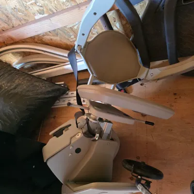 Sale Photo Thumbnail #96: Disassembled motorized stair lift chair with beige vinyl upholstery, safety belt, and associated track rails.