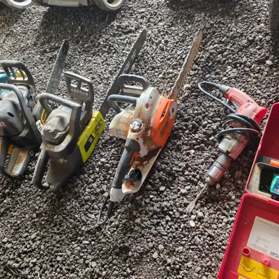 Sale Photo Thumbnail #41: Selection of power tools including a Stihl electric chainsaw, a Ryobi 20-inch chainsaw, and a heavy-duty corded drill, showing signs of moderate use.