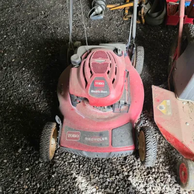 Sale Photo Thumbnail #56: Toro Recycler walk-behind lawn mower with electric start, showing some dust and wear from use.
