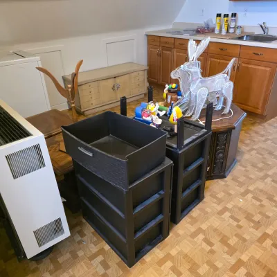 Sale Photo Thumbnail #8: Assorted household items including black plastic storage drawers, a white space heater, novelty M&M's figures, and a wireframe reindeer light decoration.