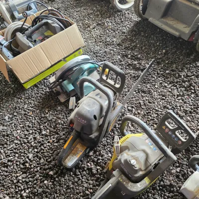 Sale Photo Thumbnail #42: Assorted power tools including two chainsaws, a circular saw, and a boxed pressure washer, showing signs of outdoor use.