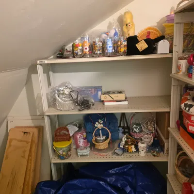 Sale Photo Thumbnail #17: Metal shelving unit holding various vintage collectibles, including Care Bears drinking glasses, plush toys, decorative baskets, and small figurines.