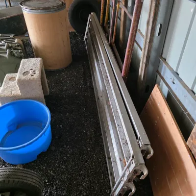 Sale Photo Thumbnail #35: Set of aluminum scaffolding planks stored in a shed, showing some wear and dirt from use.