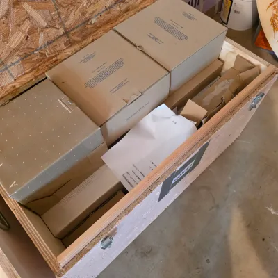 Sale Photo Thumbnail #59: Large wooden storage crate filled with various boxed items, including Avon collectible glassware and gift sets.
