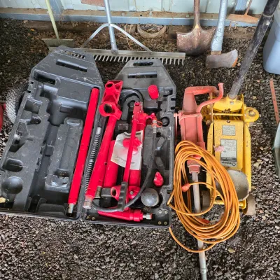 Sale Photo Thumbnail #29: Pittsburgh hydraulic porta power kit in a black plastic case, shown alongside a yellow Wilmar hydraulic floor jack and an orange extension cord.