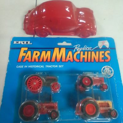 A Pair of Vintage Collectibles Including an Ertl Case IH Historical Tractor Set and an Avon Volkswagen Beetle Decanter