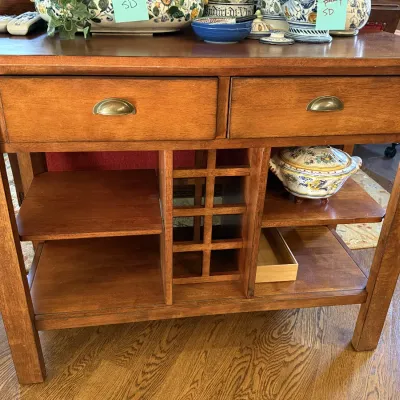 Traditional wooden server or wine console featuring two top drawers with brass cup pulls, built-in wine bottle rack, and open shelving.