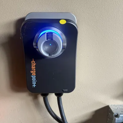 Wall-mounted ChargePoint Home Flex electric vehicle charger powered on with illuminated status ring.