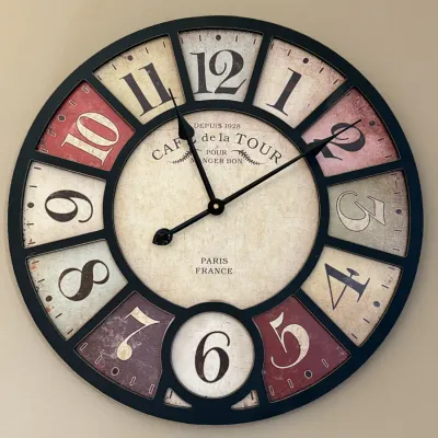 French country style wall clock featuring a black frame and distressed multi-color numbered segments.